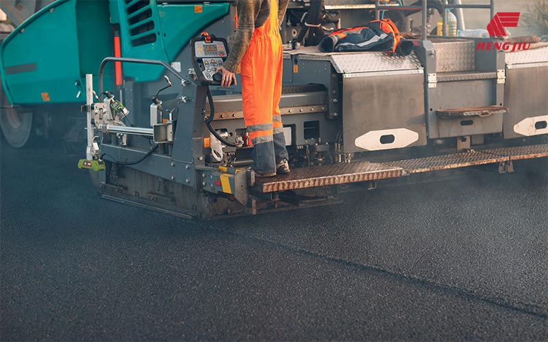 Road construction paver chain application